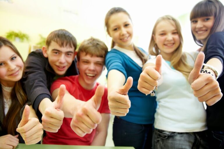 group of cheerful young students hands gesture shows OK in the classroom