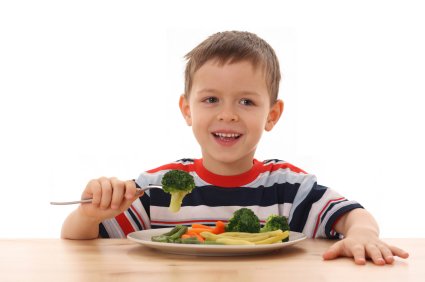 5-6 years old boy and plate of cooked vegetables isolated on white